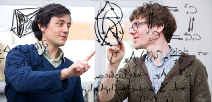 Professor explains a student something on a board.